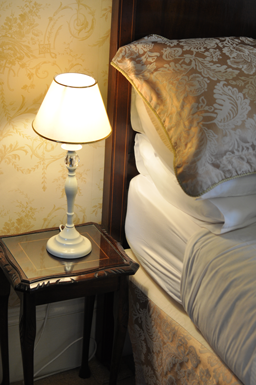 lighting next to room 4 bed and view of bedding.